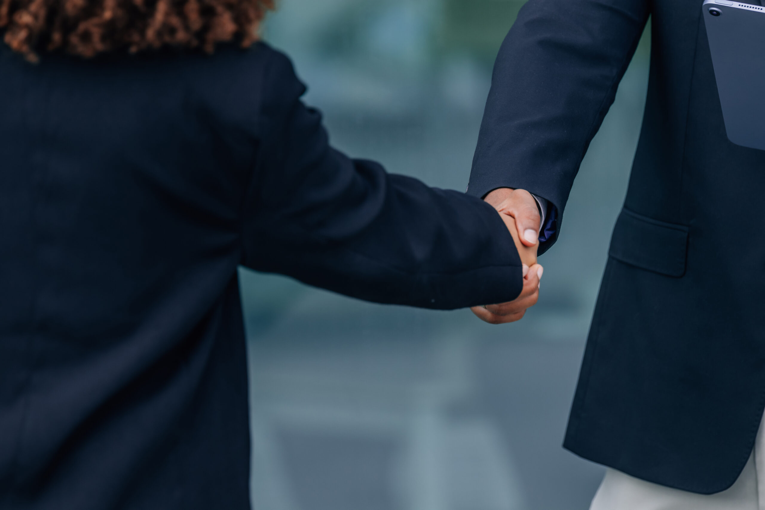 Two business professionals shaking hands in an office setting